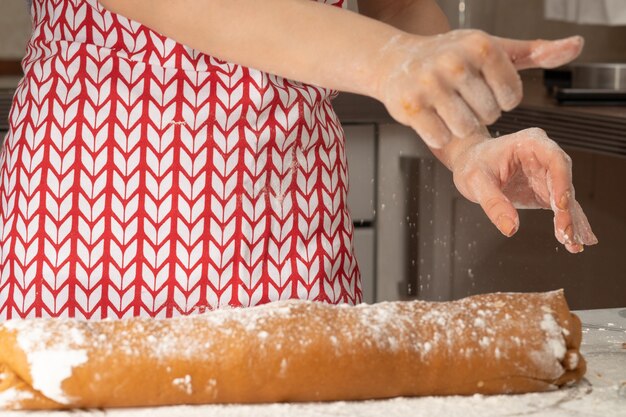 Lebkuchenteig auf dem Tisch ausrollen