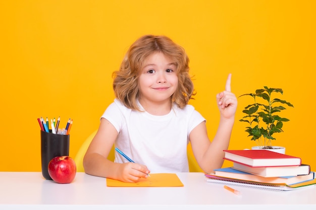 Lección de escritura para niños Escuela caucásica inteligente niño alumno estudiante que regresa a la escuela Educación niños Escolar aislado sobre fondo amarillo de estudio