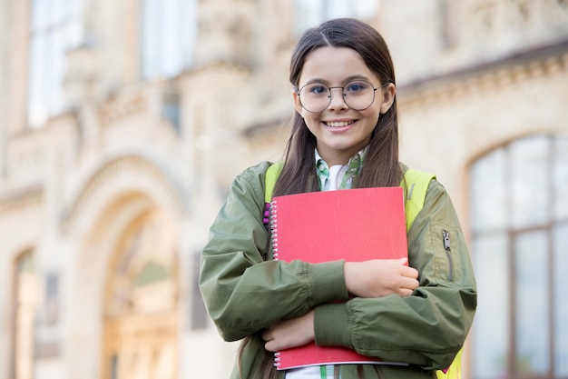 Lección interesante Niño feliz sostenga el libro al aire libre Regreso a la escuela Enseñanza y lección privada Clase y tutorial Día del conocimiento 1 de septiembre Educación formal Biblioteca escolar Listo para estudiar