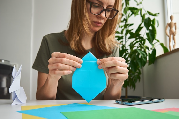 Foto lecciones de origami. mujer hacer conejo de pascua de origami de papel de color