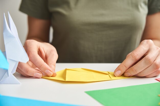 Foto lecciones de origami. mujer hacer conejo de pascua de origami de papel de color