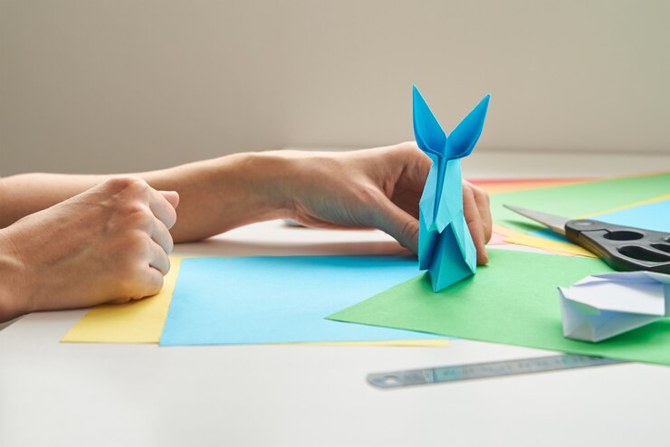 Foto lecciones de origami. mujer hacer conejo de pascua de origami de papel de color