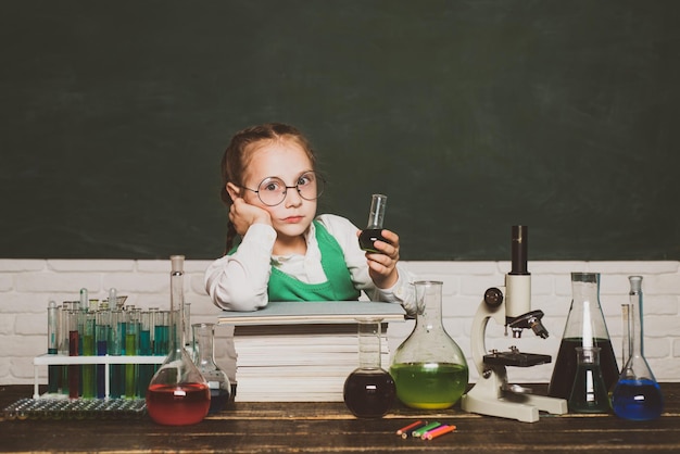 Lecciones de química escolar Niño de la escuela primaria Niño de la escuela primaria Regreso a la escuela y tiempo feliz Niño en la sala de clase con pizarra en el fondo