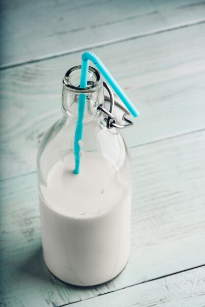 Leche de almendra en botella de vidrio con paja azul