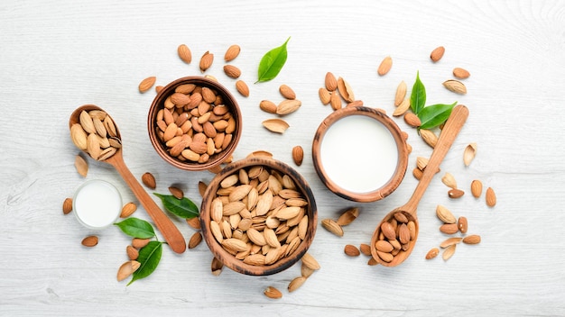 Leche de almendras y almendras en una mesa de madera blanca Vista superior Espacio libre para su texto