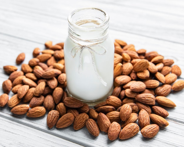 Leche de almendras con almendras en una mesa de madera