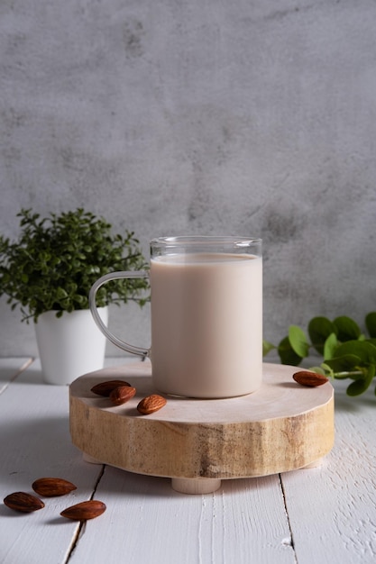 Leche de almendras con almendras sobre una mesa de madera blanca