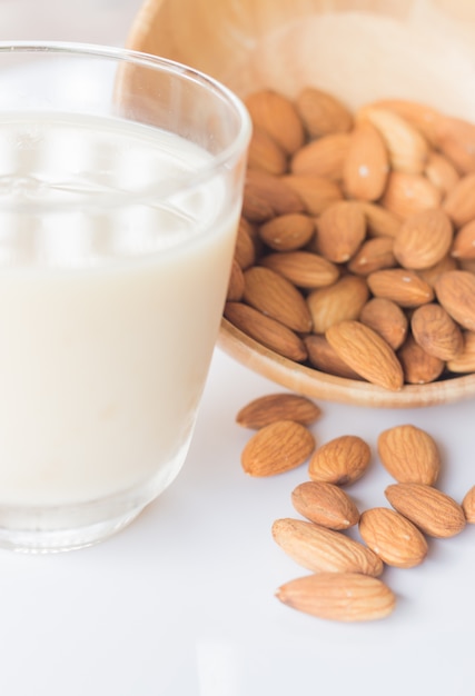 Leche de almendras y cereales en mesa de cocina blanca