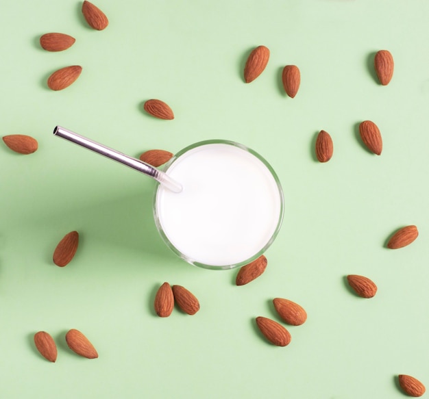 Leche de almendras en una copa de vidrio se encuentra en un verde claro