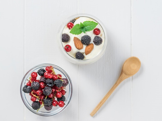 Leche almendras y granola en un recipiente de arcilla sobre una mesa de madera