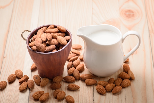 Leche de almendras en un tarro con almendras en una mesa de madera