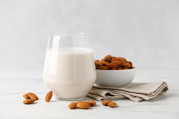 Leche de almendras en un vaso y nueces de almendras