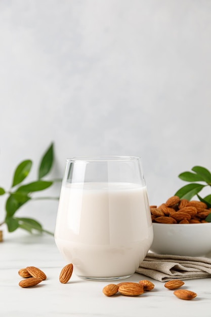 Leche de almendras en un vaso y nueces de almendras