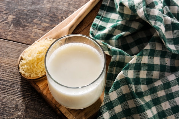 Leche de arroz en vidrio en la mesa de madera.