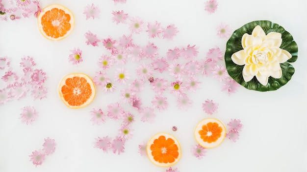 Leche de baño decorada con rodajas de pomelo y flores