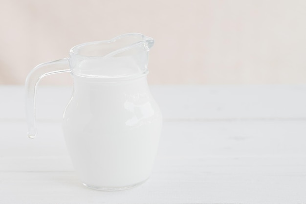 Leche. Botella de leche y vaso de leche sobre mesa de madera. Jarra de vidrio y vaso con leche. Concepto de alimentación saludable
