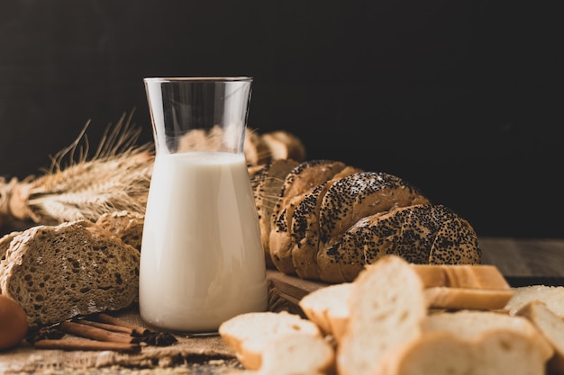 Leche en una botella de vidrio colocada sobre una mesa de madera con ingredientes