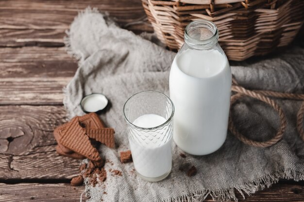 Leche en botella de vidrio y vidrio. Comida sana. Vista vertical