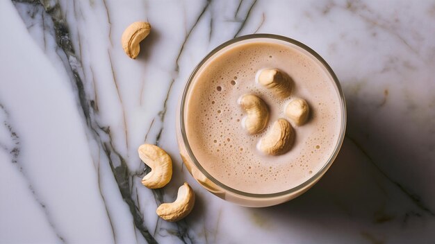 Foto leche de caju vegana en vaso con nueces de caju sobre un fondo de mármol