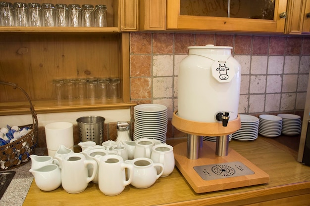 Leche caliente y fresca para beber y mezclar con café en la sala del restaurante en el hotel resort en Pfunds por la mañana en el Tirol, Austria