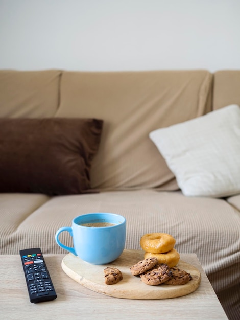 Leche caliente con galleta y donut para merendar en el salón