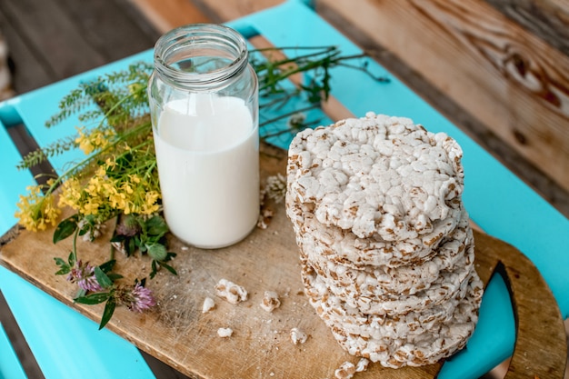 Leche casera y pan crujiente sabroso en mesa de madera