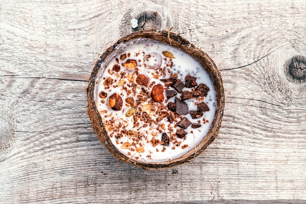 Leche de coco y granola en una cáscara de coco