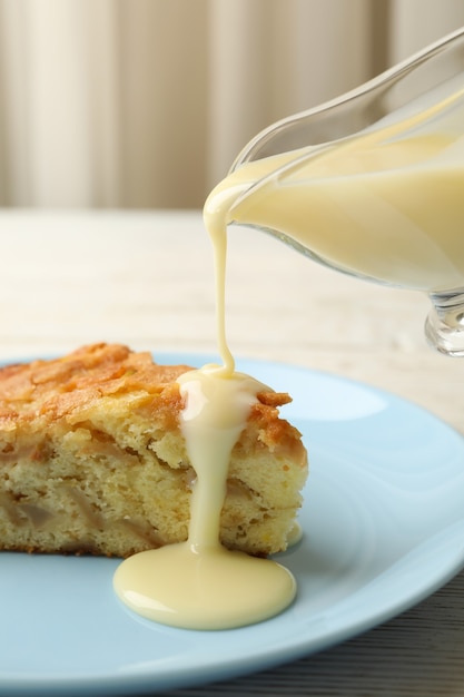 La leche condensada se vierte desde la salsera en el pastel