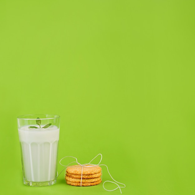 Foto leche en copa sobre fondo verde