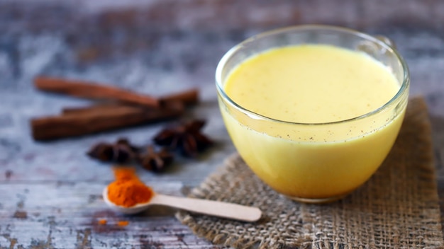 Leche de cúrcuma con especias en una taza. Leche de cúrcuma dorada. Bebida india de salud. Enfoque selectivo.