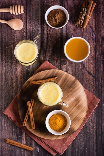 Leche dorada de miel de cúrcuma en vasos El tratamiento en el hogar mejora la inmunidad Vista superior y vertical