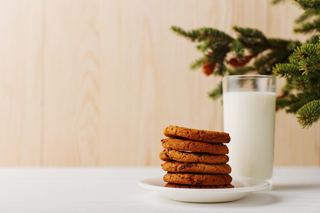 Leche y galletas para Santa Claus bajo el árbol de navidad