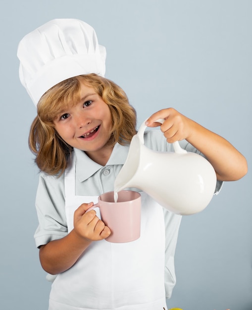 Leche para niños Retrato de niño pequeño en forma de cocinero aislado sobre fondo gris Kid chef Proceso de cocción