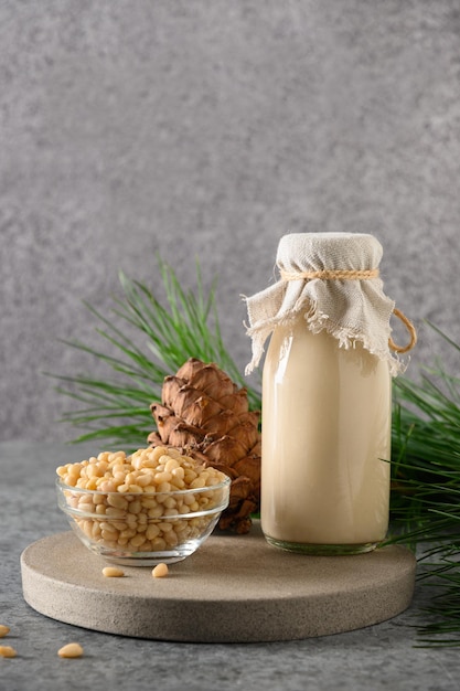 Leche de nuez de cedro vegana sobre fondo gris Leche alternativa no láctea