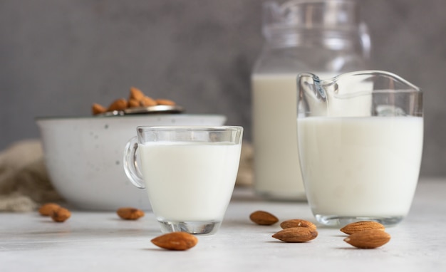 Leche orgánica de almendras en jarras de vidrio con ingredientes.