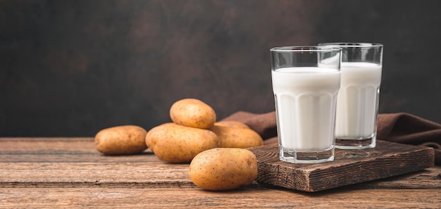 Leche de patata en dos vasos sobre el fondo de patatas una alternativa a la leche de vaca