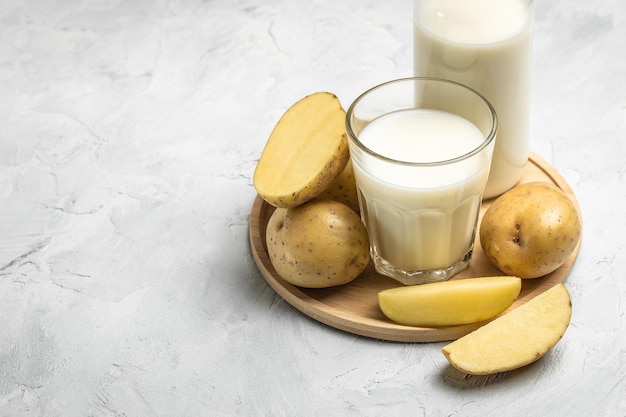 Leche de patata vegana en vidrio y patata cruda Concepto alternativo de superalimento de leche a base de plantas Alimentación sana y limpia Dieta vegana o sin gluten vista superior