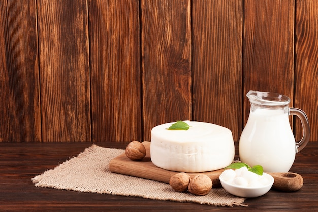 Leche y queso sobre tabla de cortar.