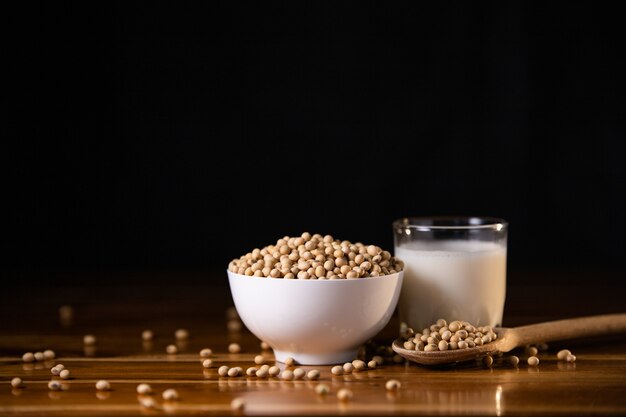 Leche de soja caliente y soja sobre fondo de mesa de madera