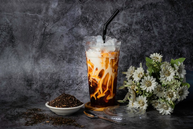 Leche de té rojo en un vaso de plástico con hielo