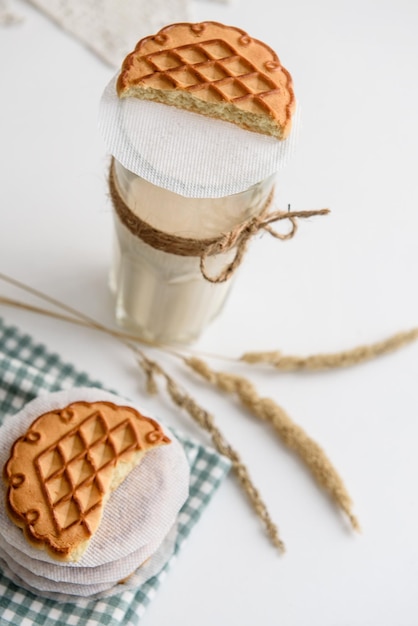 Leche en un vaso y galletas en la mesa