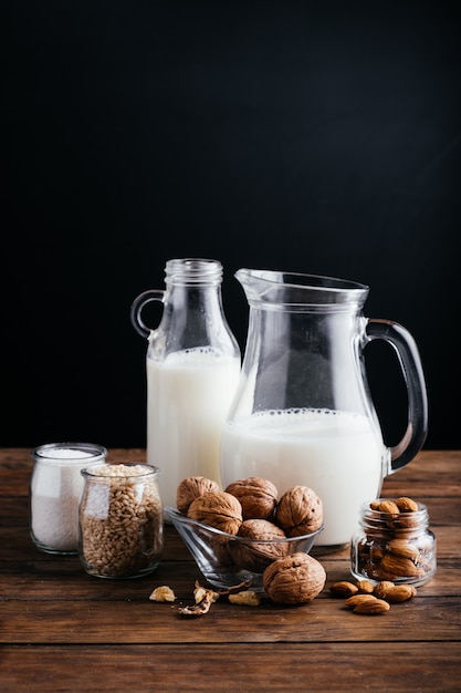 Leche vegetal sobre fondo de madera, leche de almendras, leche de nueces, leche de arroz y leche de coco