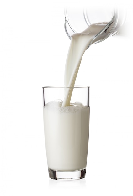 Foto leche vertiendo en un vaso de jarra de vidrio