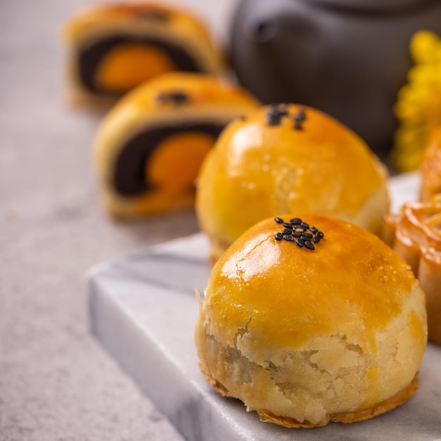 Lecker gebackener Eigelb-Gebäck-Mondkuchen für MidAutumn Festival auf hellem Zementtischhintergrund Chinesisches traditionelles Lebensmittelkonzept Nahaufnahme Kopierraum