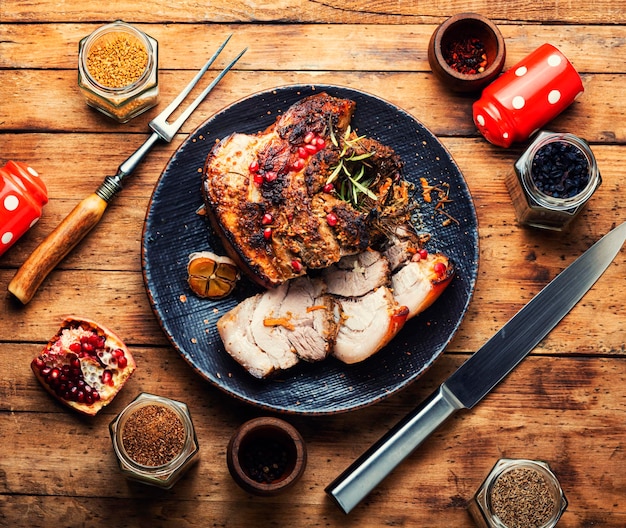 Lecker gebratener Schweinebauch mit Gewürzen und Kräutern Fettiges Stück Fleisch auf altem Tisch