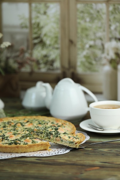 Lecker Quiche-Torte mit Lachsfisch und Piniennüssen zum Füllen Frühstück mit Quiche und einer Tasse Tee