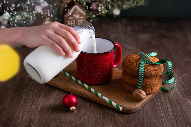 Leckerbissen für das Weihnachtsmann-Kind vorbereiten, das Milch und Kekse in die Nähe des Weihnachtsbaums legt