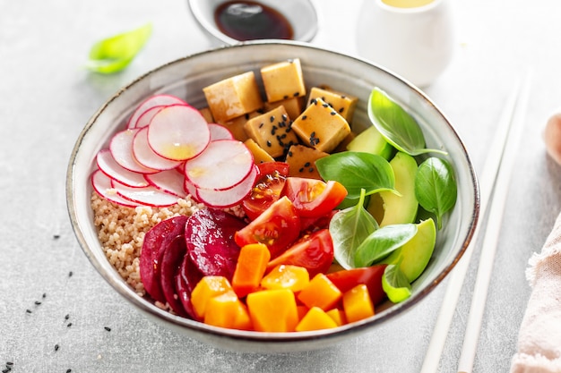 Leckere appetitliche vegane Schüssel mit Gemüse und Tofu in der Schüssel serviert. Nahansicht.
