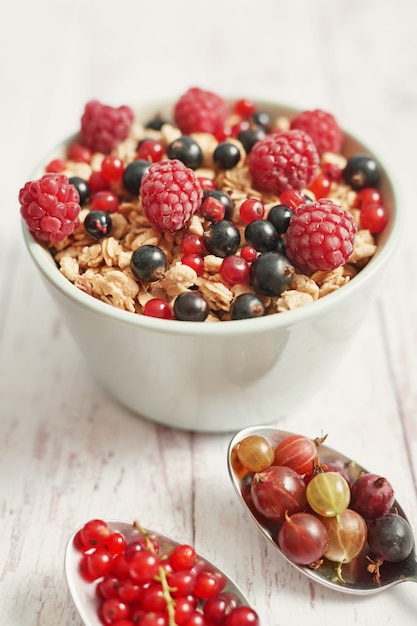 Leckere Beeren in einer weißen Tasse und Löffeln