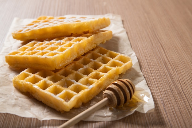 Leckere belgische waffeln mit honig. bäckereiprodukte. essen